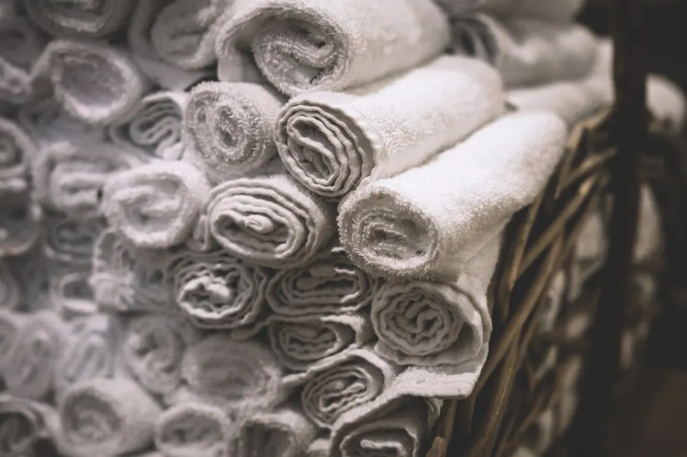 Rolled white towels in a woven basket