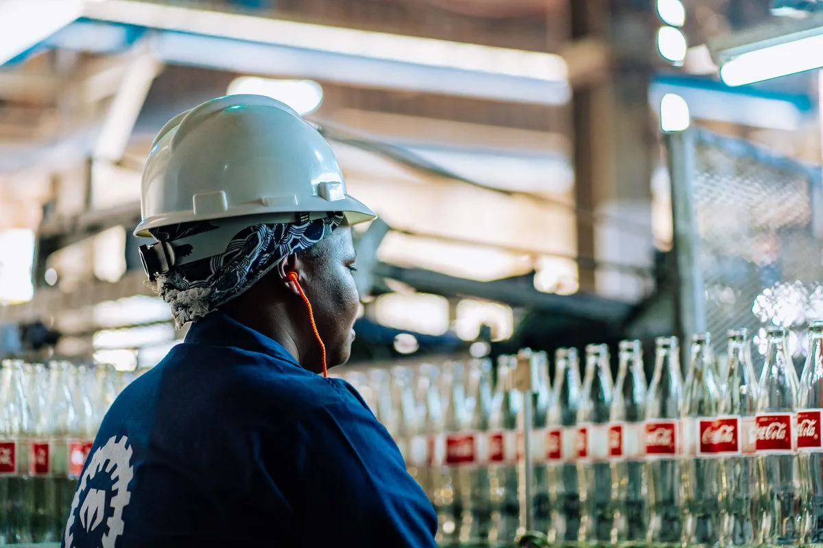 Worker inspecting bottles in a manufacturing facility