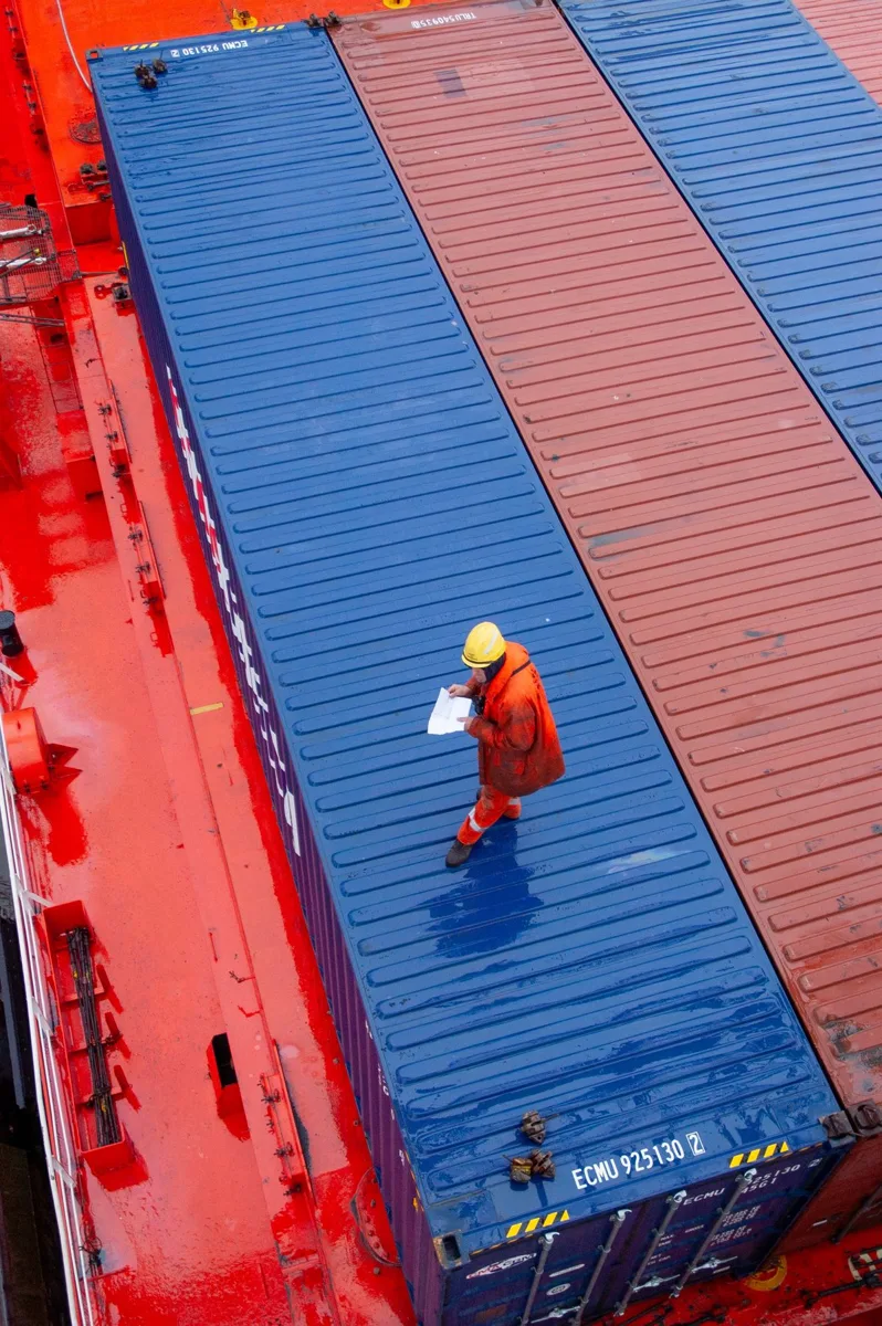 Port worker checking shipping container loading
